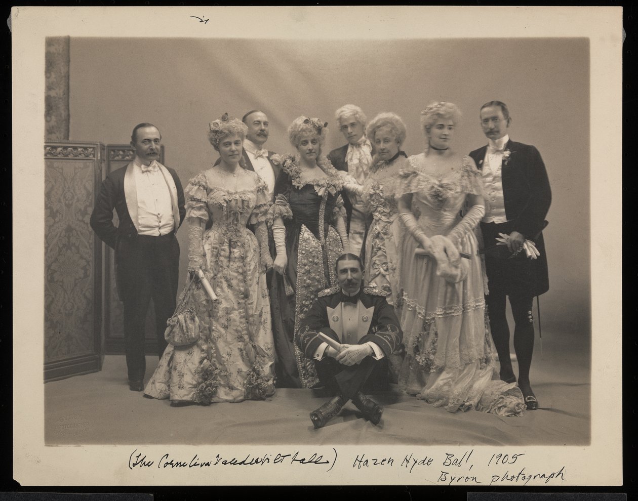 Portræt af fem mænd (inklusive Coleman Drayton, August Belmont og Frank Hoppin siddende på gulvet) og fire kvinder (inklusive Mrs. Stuyvesant Fish) ved James Hazen Hyde Ball, New York, den 31. januar af Byron Company