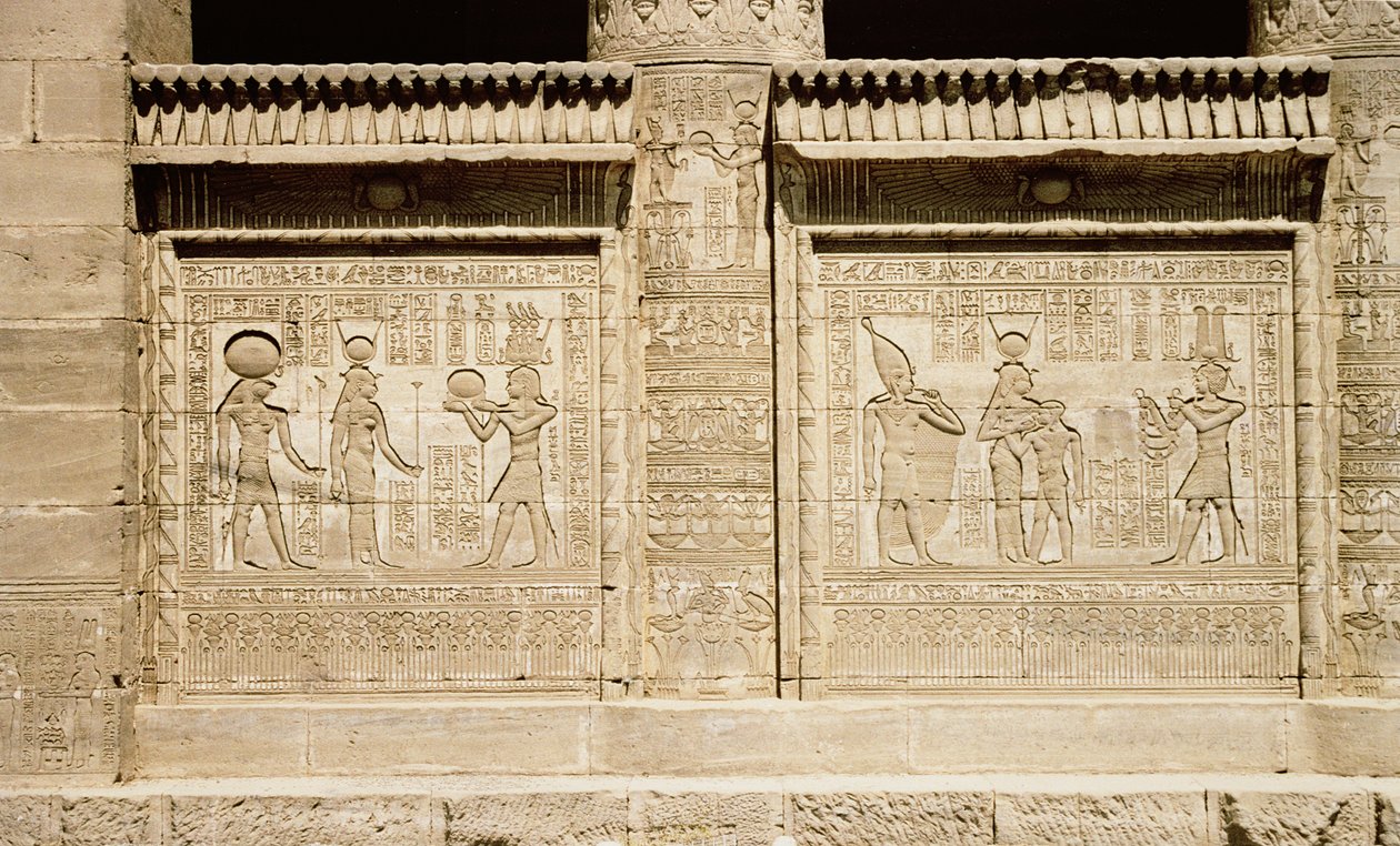 To relieffer, der til venstre forestiller en farao, der bringer et offer til Hathor og Horus, og til højre, Hathor, der dier den unge Ihy med en anden Ihy, der bærer Øvre Egyptens hvide krone, der står bag h. af Greco-Roman