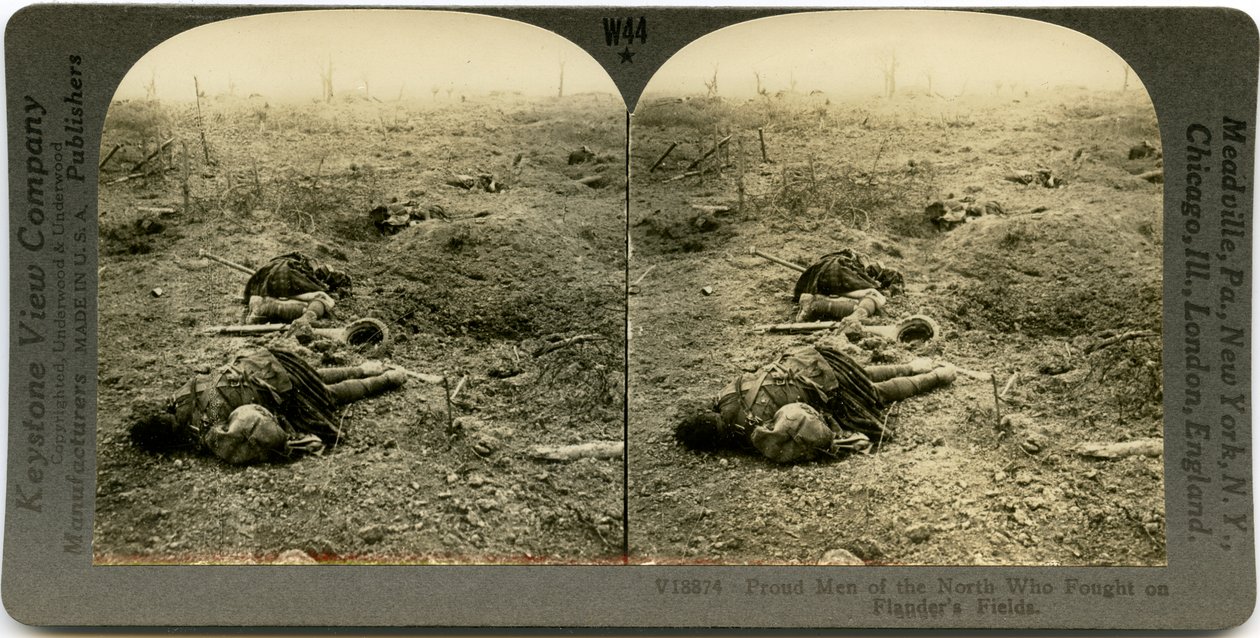 Horisontalt sepia -stereokort, der viser et åbent felt med fire døde skotske soldater med rester spredt rundt. Keystone stereograf nummer V18874. af Keystone View Company