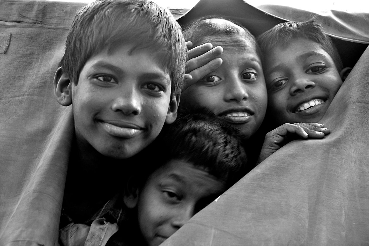 Nødfattige børn ser gennem et iturevne lærred af en politivogn i Dhaka by, Bangladesh. 26. november 2006. af Unknown