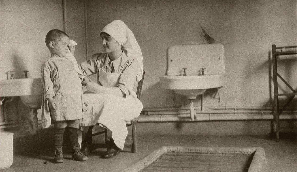 Sygeplejerske passer et sygt barn i Passay- og Saint-Quentin-kolonierne for flygtninge og forældreløse børn, 1919 af American Photographer