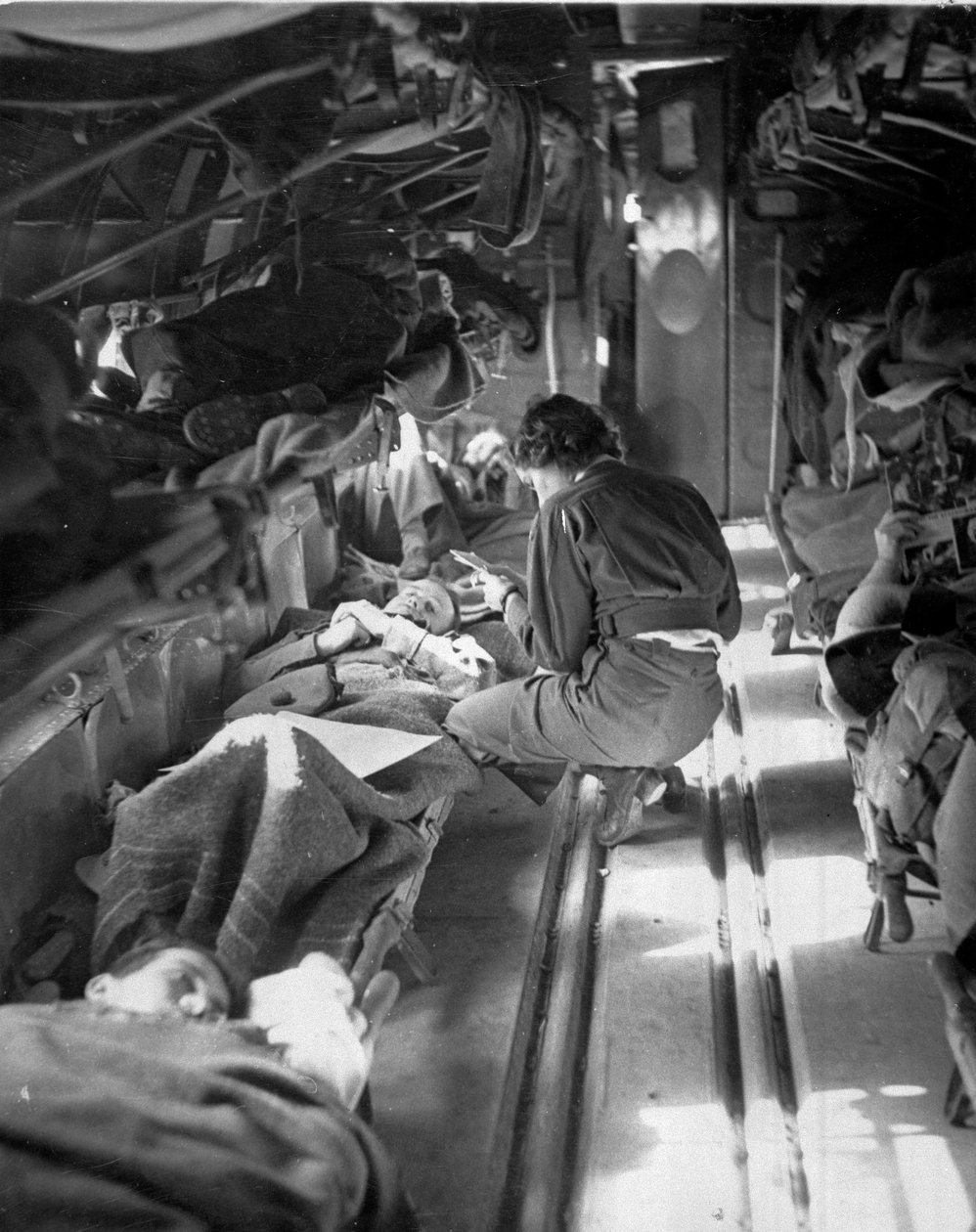 Miss Mary Smith fra South Carolina behandler patienter under flyvningen til Nordafrika, ca. 1943-45, fra en samling på 650 fotografier udarbejdet af Commando Association af American Photographer