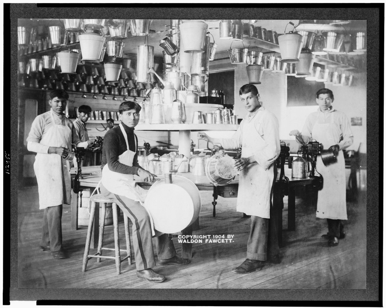Unge indfødte amerikanske mænd i metalbearbejdningsworkshop med spande, Washtubs, vanddåser og andre metalartikler, Carlisle Indian School, Pennsylvania, C.1904 (B/W Photo) af American Photographer