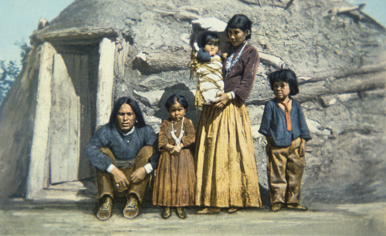 Postkort af en Navajo indisk familie uden for deres hus eller 