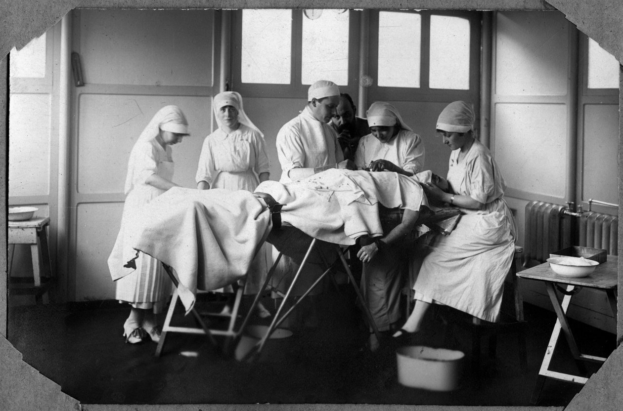 Første Verdenskrig 1914-1918: læger og sygeplejersker fra det røde kors (Therese Pavillou?) behandler en soldats sår, der sover i kloroform, i lejren Couville i Manche, Basse-Normandie (Nedre Normandiet), Frankrig. Anonym fotografering af Anonymous Anonymous
