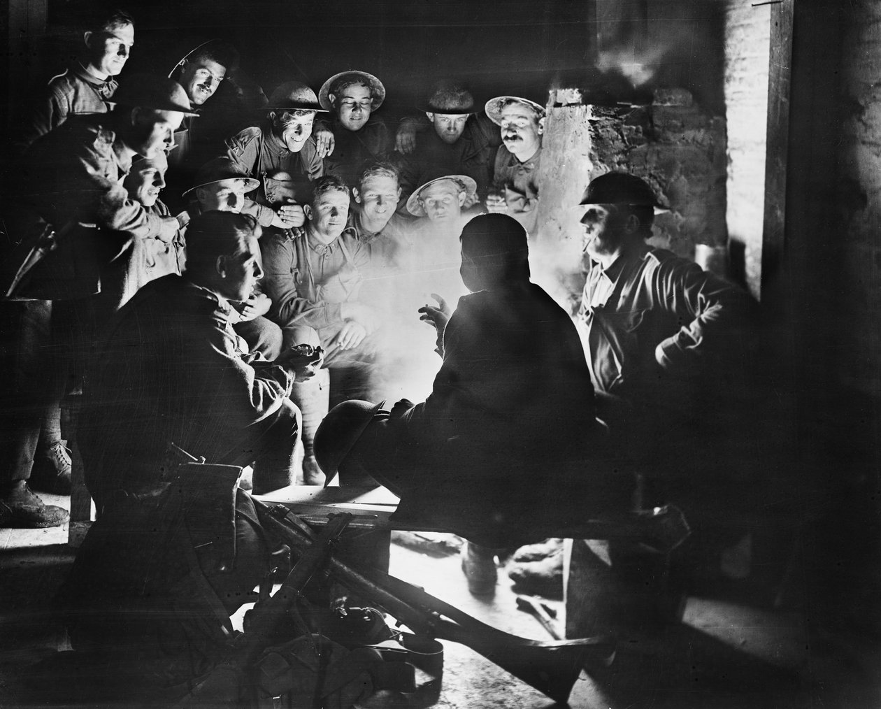Medlemmer af 1st Australian Light Trench Mortar Battery, 1st Australian Division lytter til det seneste fra en af deres kammerater omkring en ild i en udgravet billet i Ypres, 28. oktober 1917 (bw pho af Australian Photographer