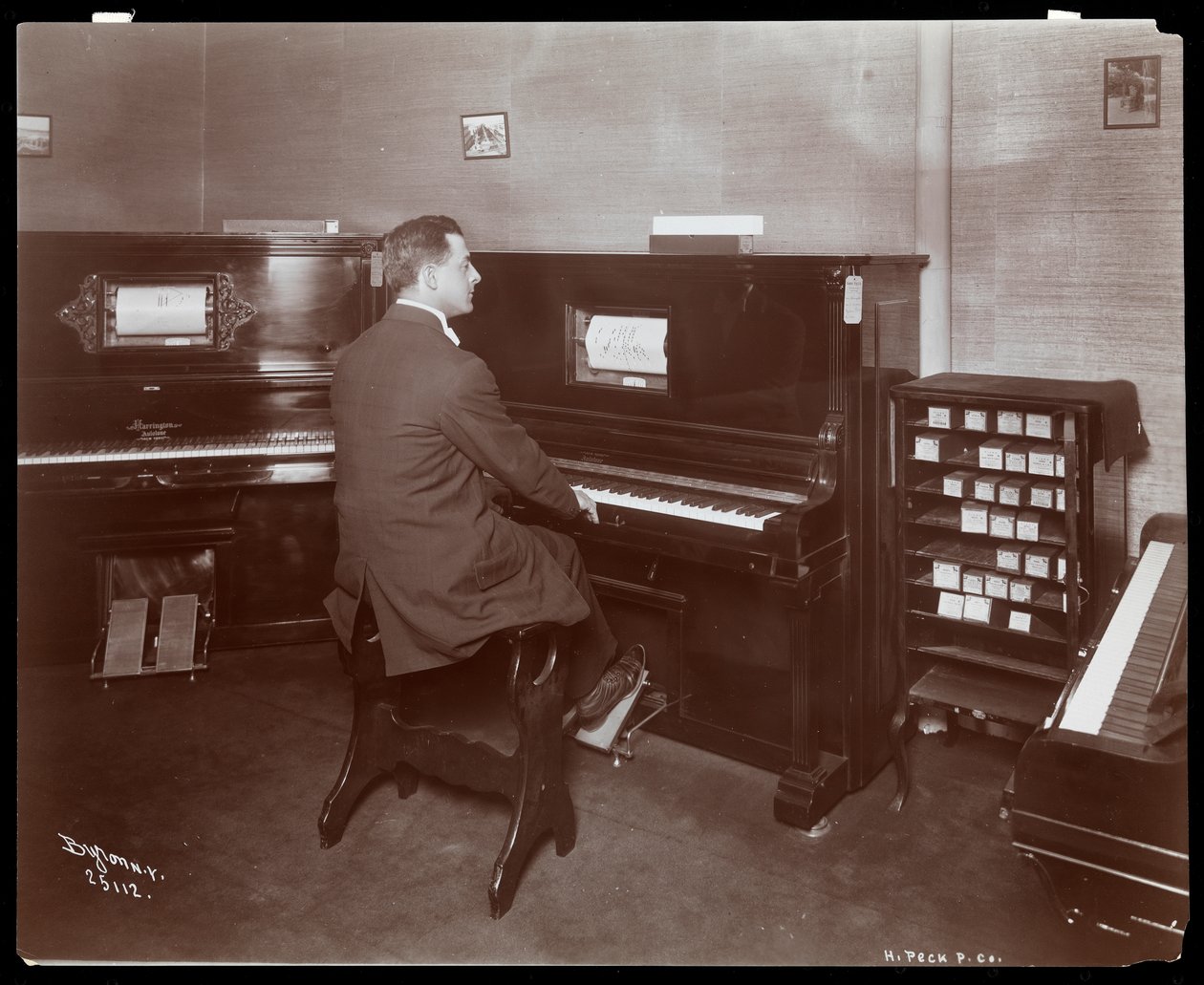 En mand, der spiller klaver i et klaverudstillingslokale i New York, 1907 (sølv gelatinetryk) af Byron Company