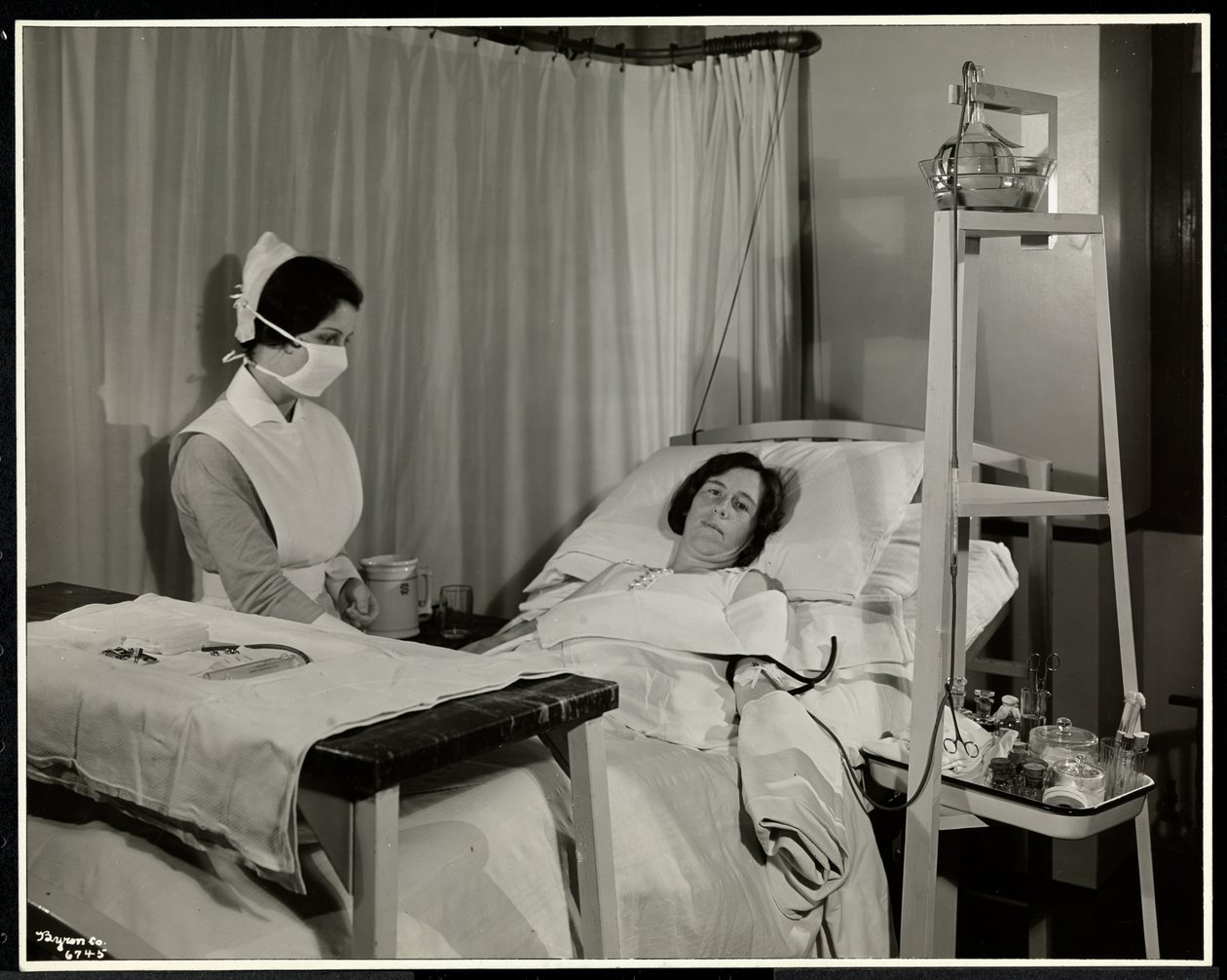 En maskeret sygeplejerske med en patient i et værelse på Sloane Medical Hospital, Broadway og 168th Street, New York, 1932 (sølv gelatinetryk) af Byron Company