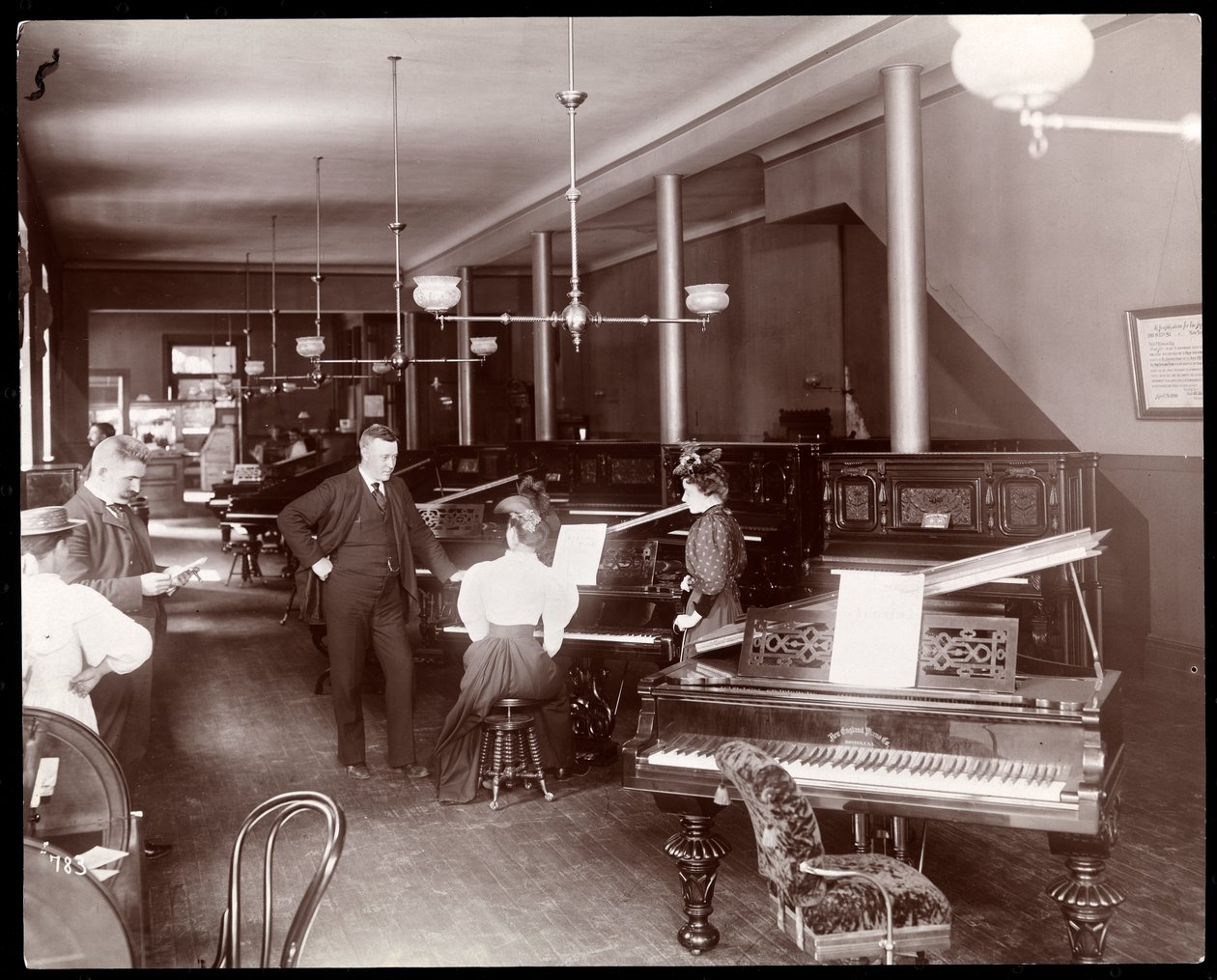 Et udstillingslokale for New England Piano Co., 1895 (sølv gelatinetryk) af Byron Company