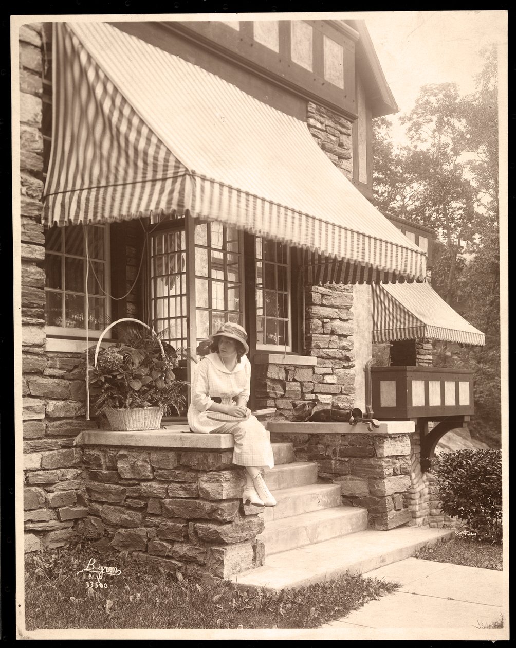 En kvinde siddende ved indgangen til et hus, 1915 (sølv gelatinetryk) af Byron Company