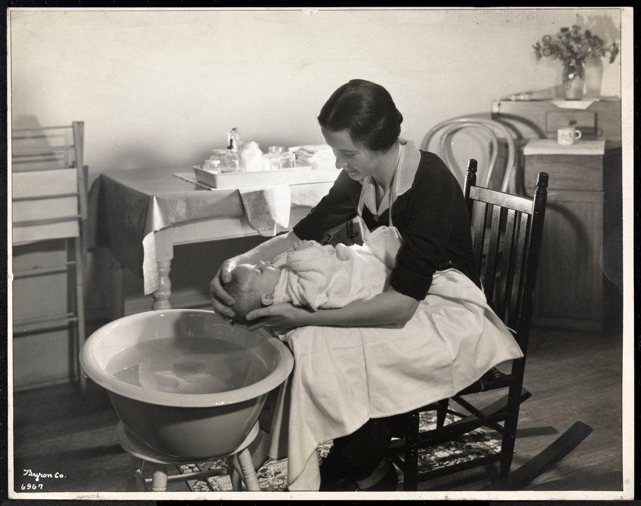En kvinde vasker en babys hoved hos Maternity Center Association på 211 East 57th Street, New York, 1934 (sølv gelatinetryk) af Byron Company