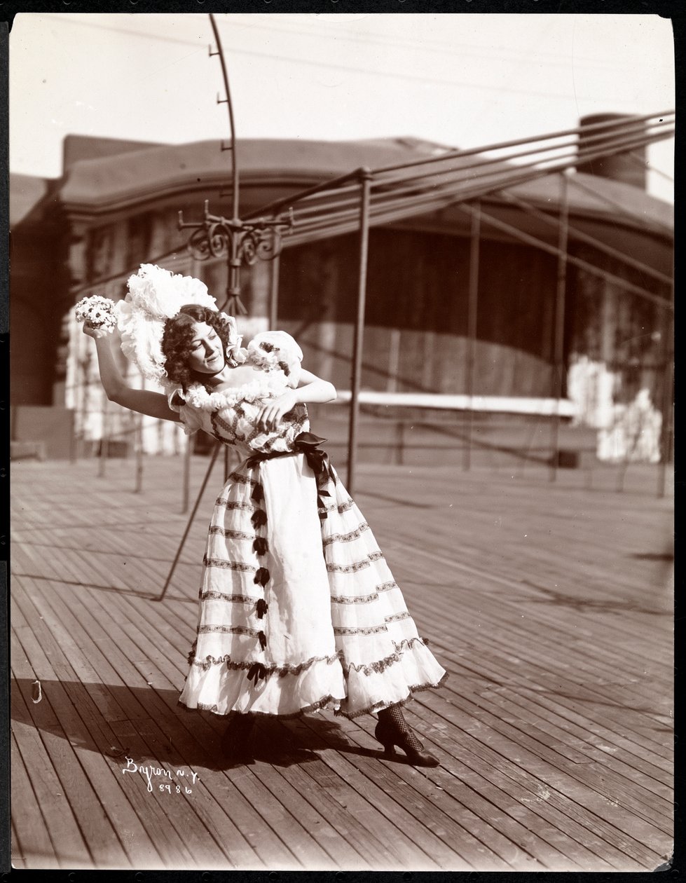 En skuespillerinde i kostume, der øver på taget af det, der sandsynligvis er New York Theatre, New York, 1900 (sølv gelatinetryk) af Byron Company