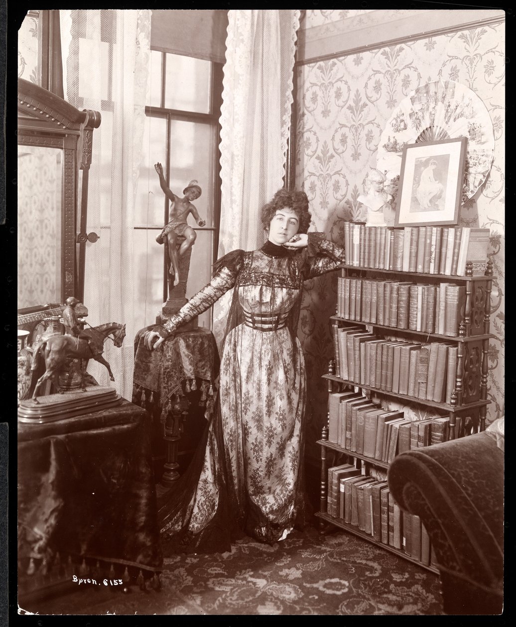 Anita Chartres i hjørnet af et værelse, ca. 1898 (sølv gelatinetryk) af Byron Company