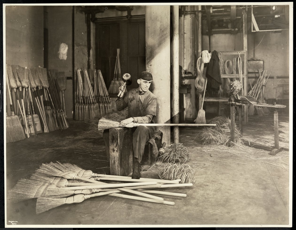 Blind mand placerer jernbøjler på koste i Bourne Memorial Building, New York, 1921 (sølv gelatinetryk) af Byron Company