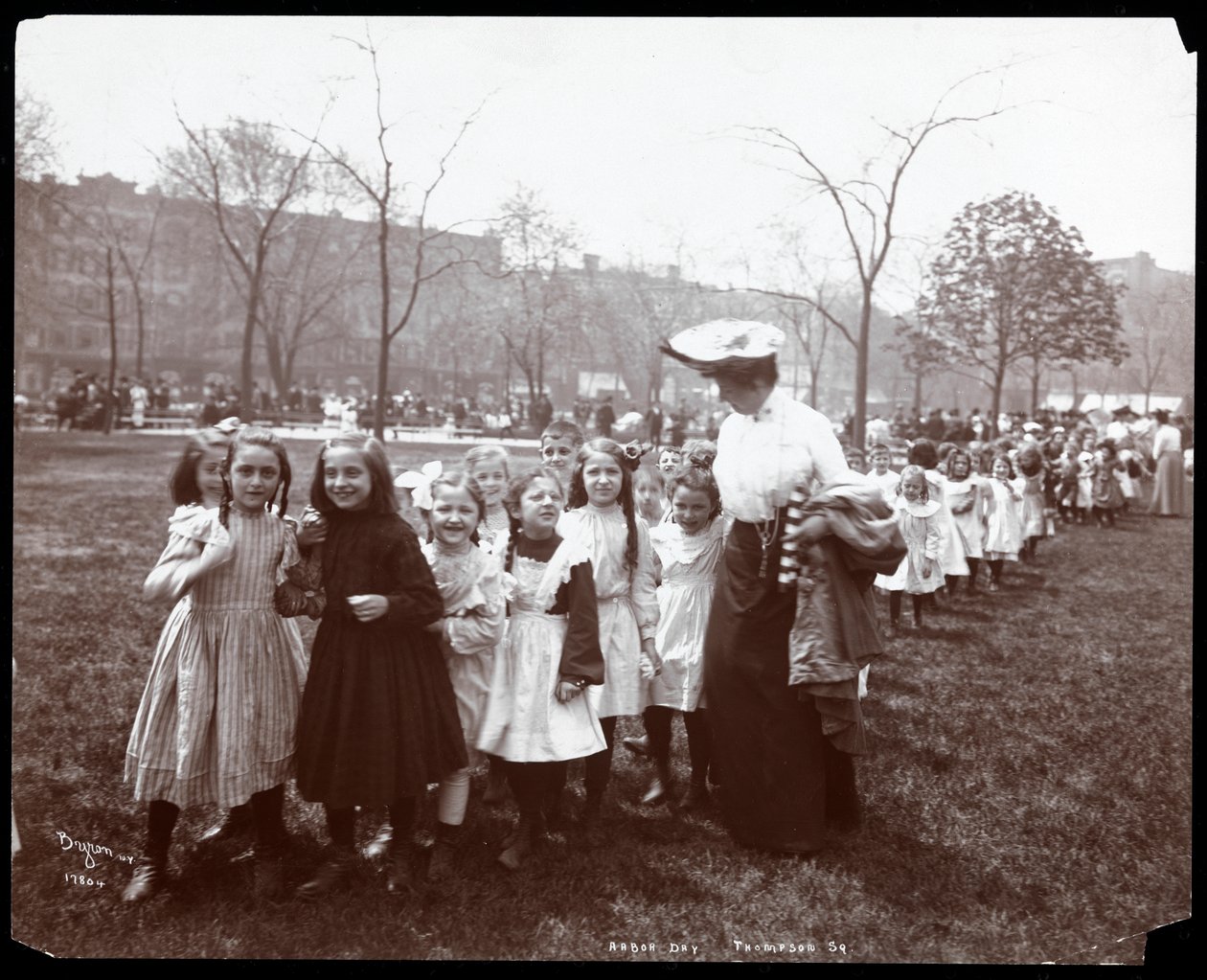 Børn i en lang række ledet af en kvinde på Arbor Day i Tompkins Square Park, New York, 1904 (sølv gelatinetryk) af Byron Company