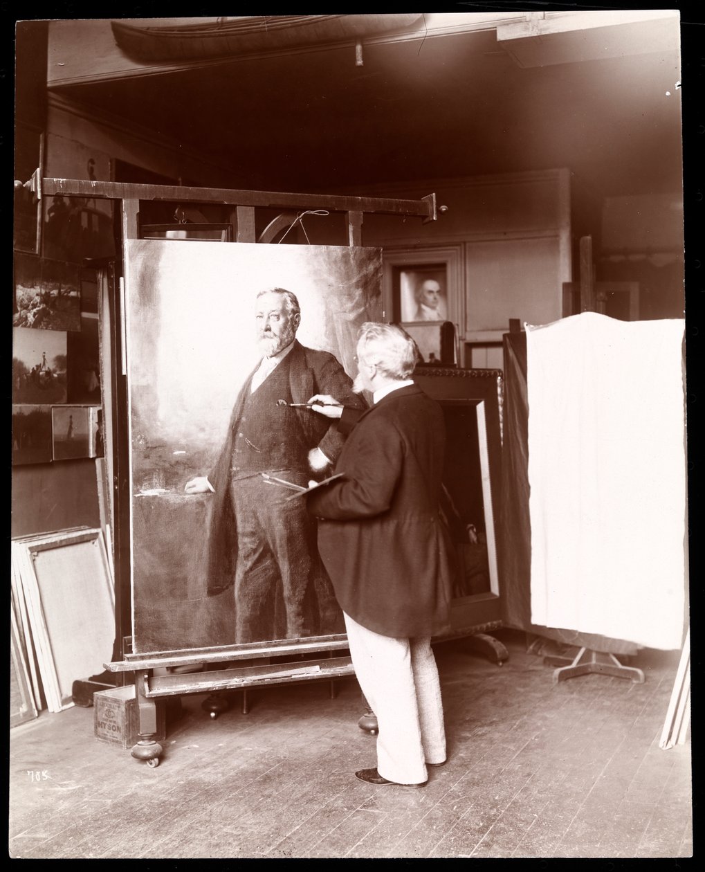 Eastman Johnson med pensel i hånden arbejder på et portræt af præsident Harrison i sit atelier, New York, 1895 (sølvgelatineprint) af Byron Company