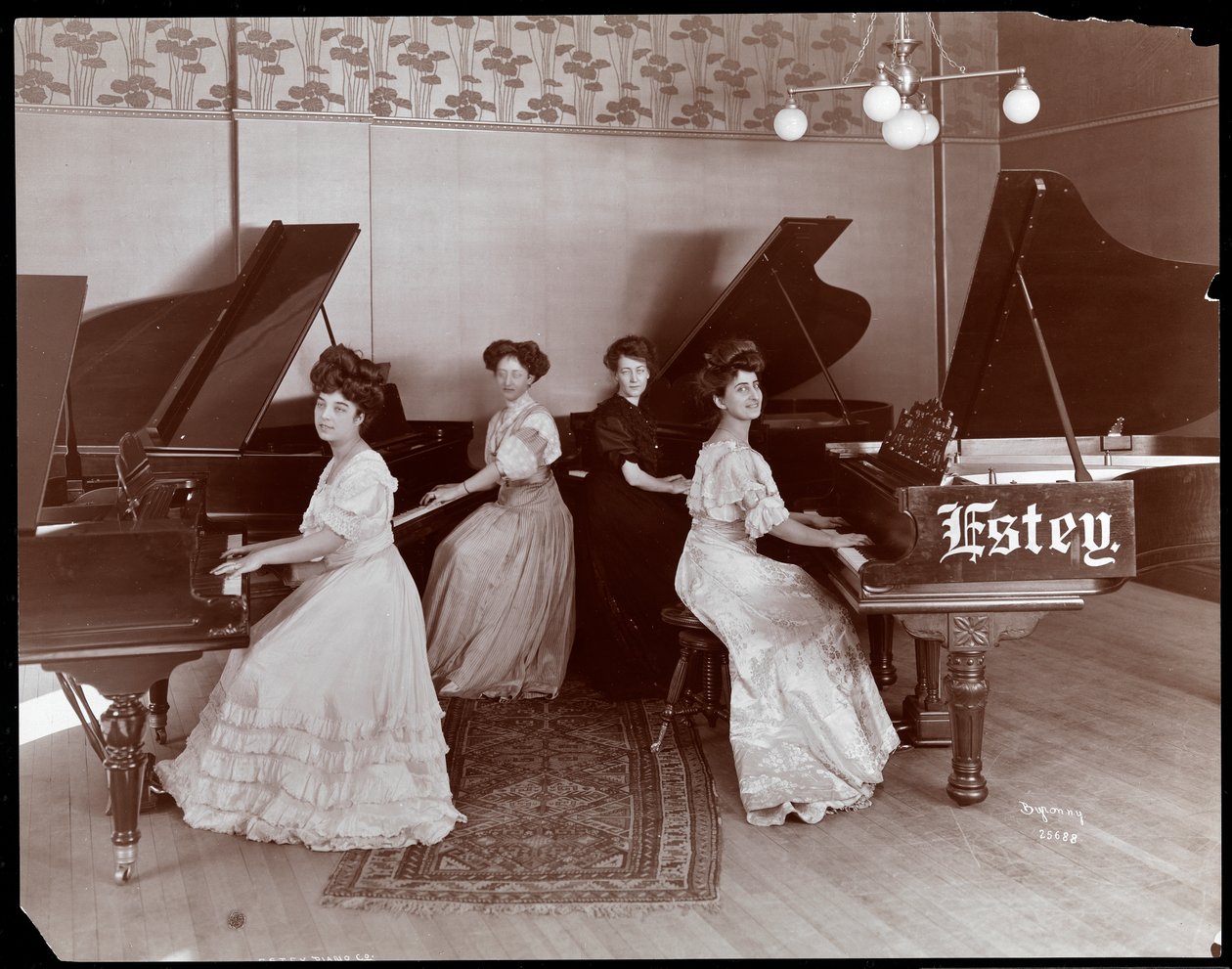 Fire kvinder ved klaverer hos Estey Piano Corporation, 1908 (sølvgelatineprint) af Byron Company