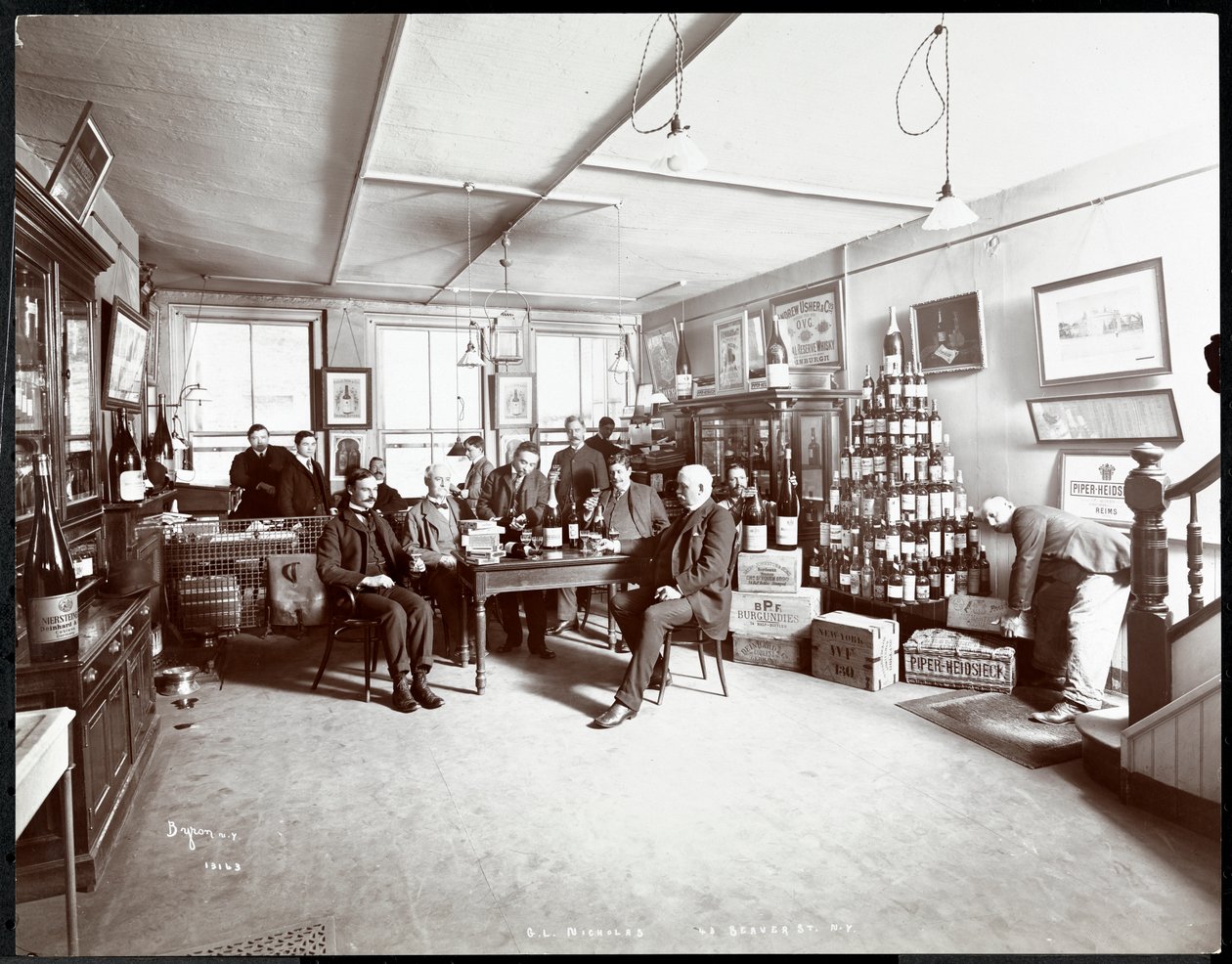 Gruppe af mænd drikker vin hos G.L. Nicholas, vin- og spiritusforhandler, 43 Beaver Street, New York, 1895 (sølvgelatineprint) af Byron Company