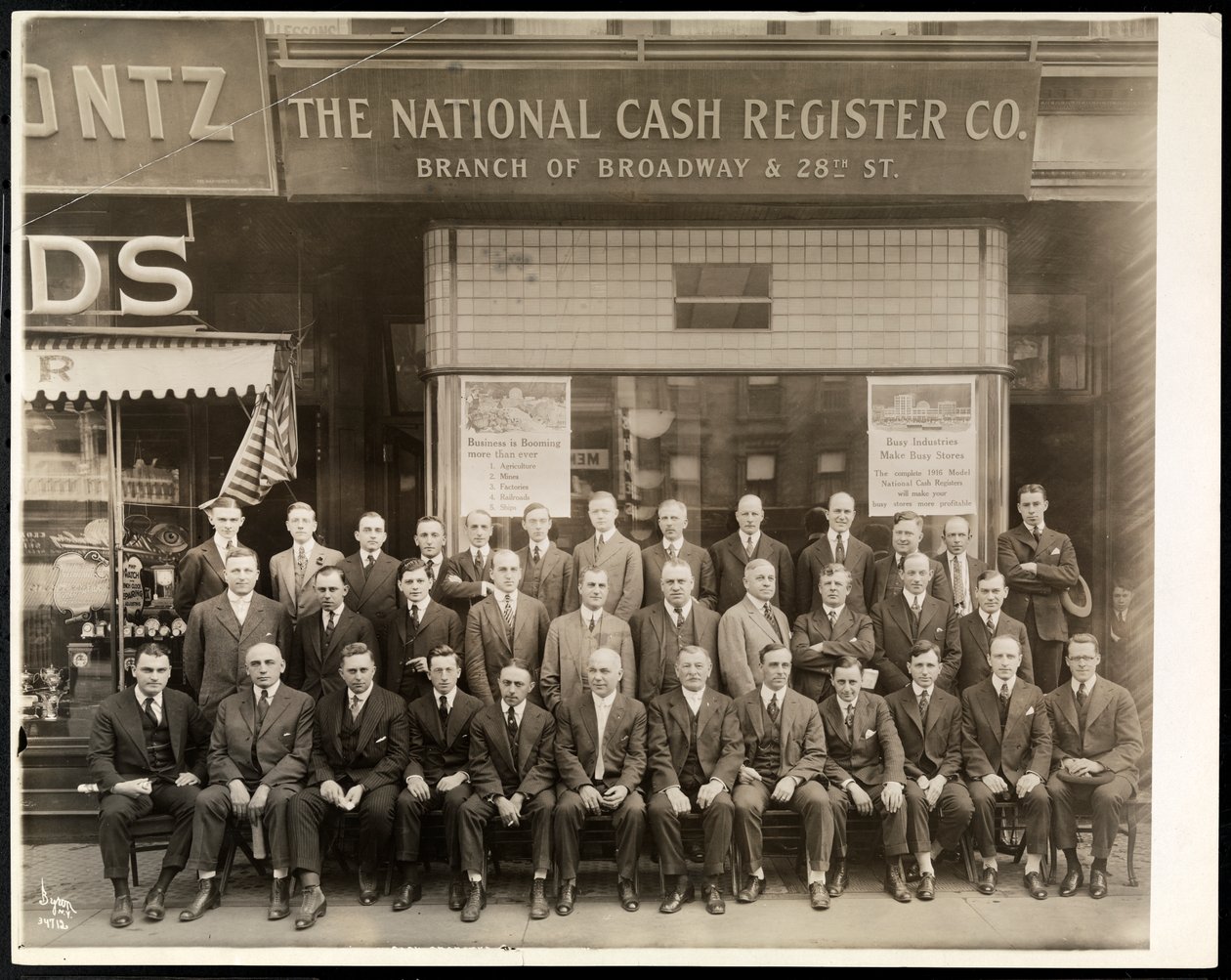 Gruppe af mænd fra National Cash Register Co. poserede foran Broadway og 28th Street filial, New York, 1916 (sølv gelatinetryk) af Byron Company