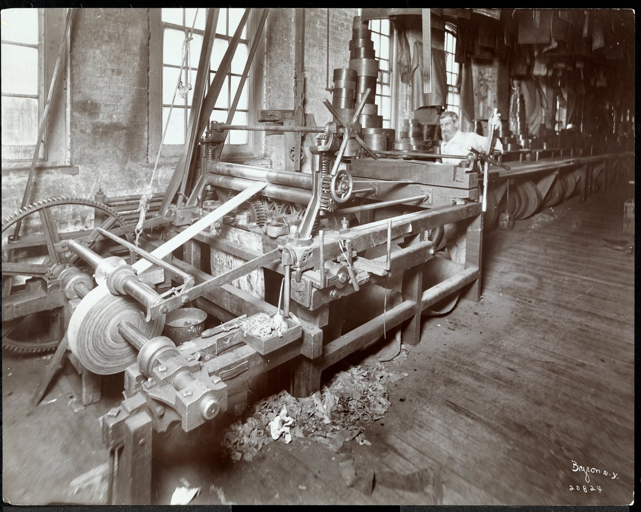 Indvendigt billede af en mand, der arbejder med læder på New York Leather Belting Co., New York, 1906 (sølv gelatinetryk) af Byron Company