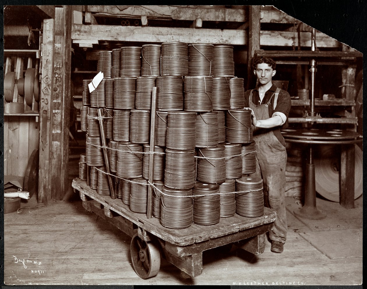 Indvendigt billede af en mand, der arbejder med læder på New York Leather Belting Co., New York, 1906 (sølv gelatinetryk) af Byron Company
