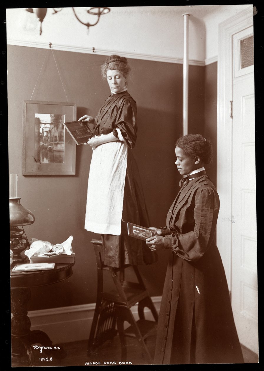 Madge Carr Cook hængende billeder med sin stuepige, ca. 1904 (sølv gelatinetryk) af Byron Company