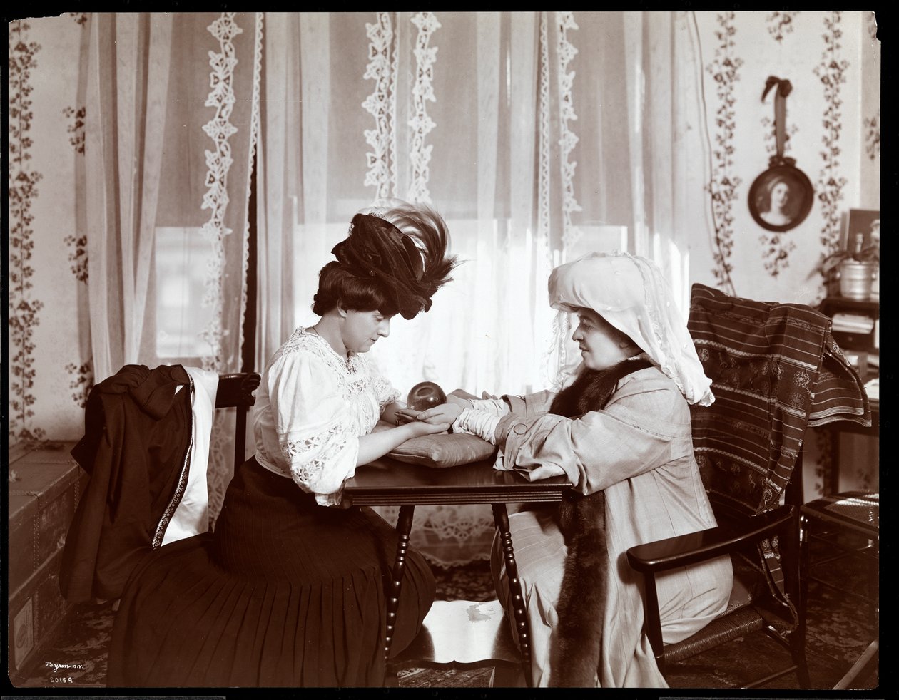 Mrs. Leslie Carter siddende sammen med en kvinde, der læser en krystalkugle, 1904 (sølvgelatineprint) af Byron Company