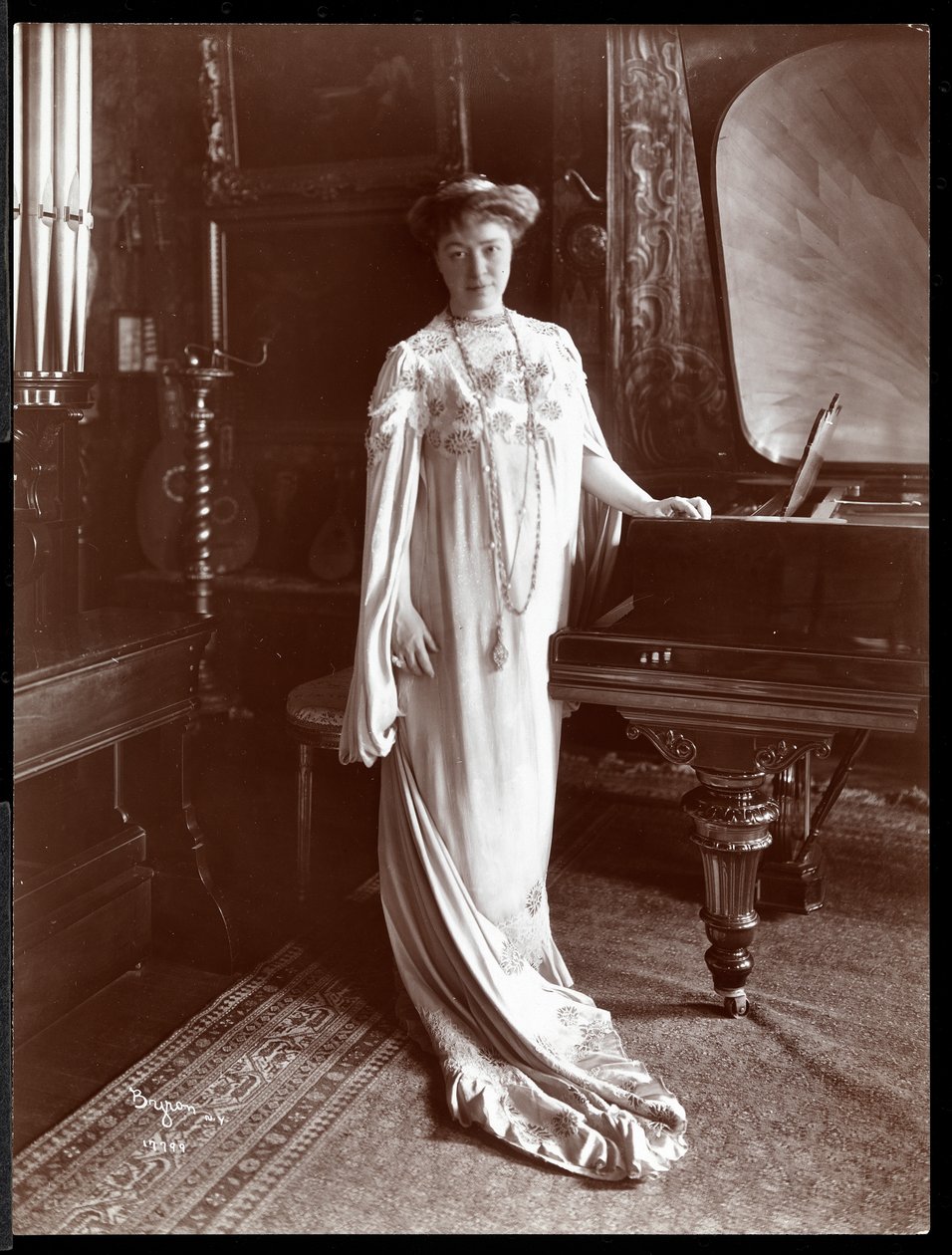 Portræt af fru I. M. Clark stående ved et klaver, 1904 (sølvgelatineprint) af Byron Company