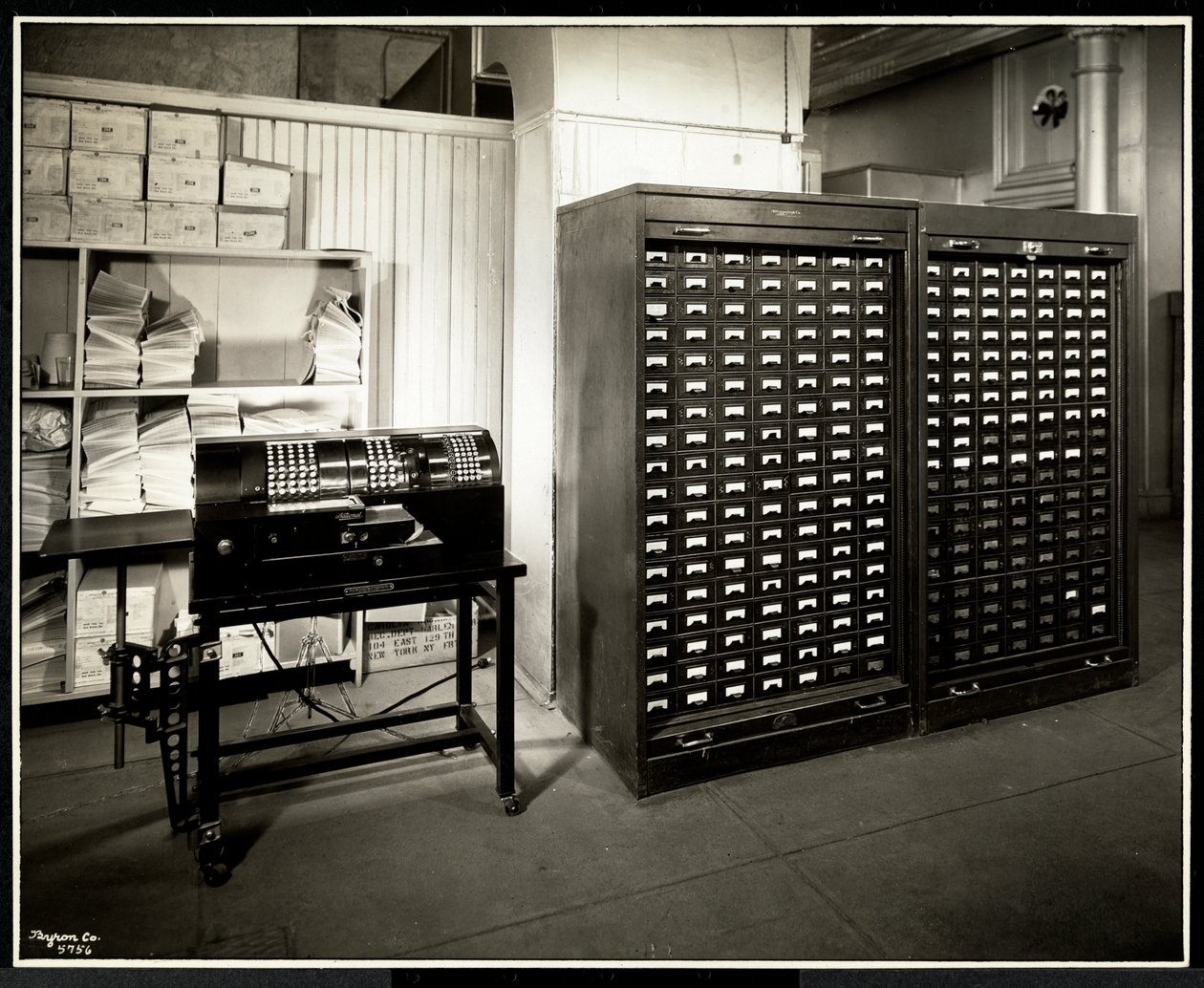 Muligvis en tilføjelsesmaskine og et arkivskab med små skuffer på kontoret til Carolyn Laundry på 111 East 128th Street, East Harlem, New York, 1929 (sølv gelatinetryk) af Byron Company