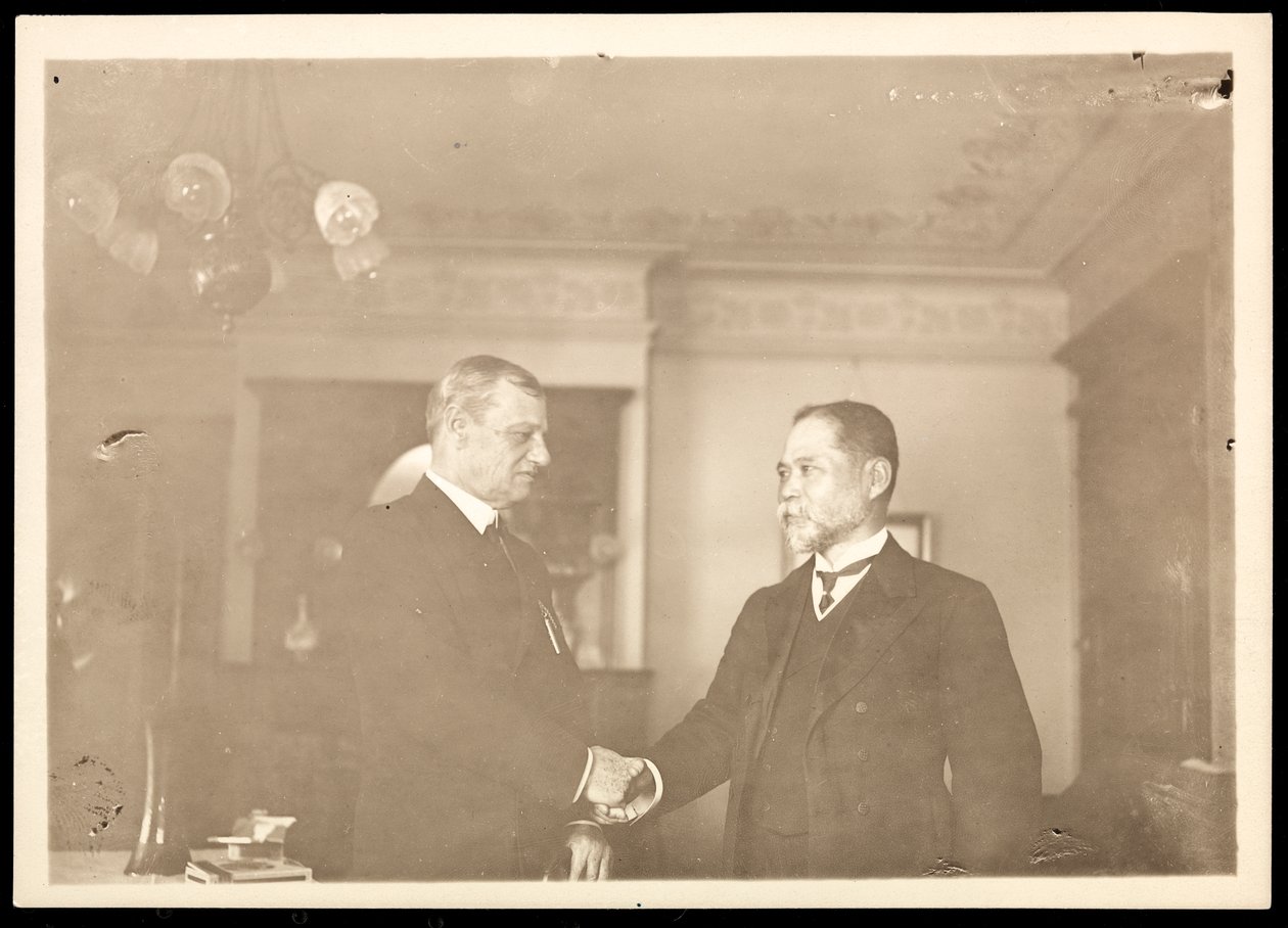 Kontreadmiral Robley Dunglison Evans giver hånd til en anden mand, 1906 (sølvgelatineprint) af Byron Company