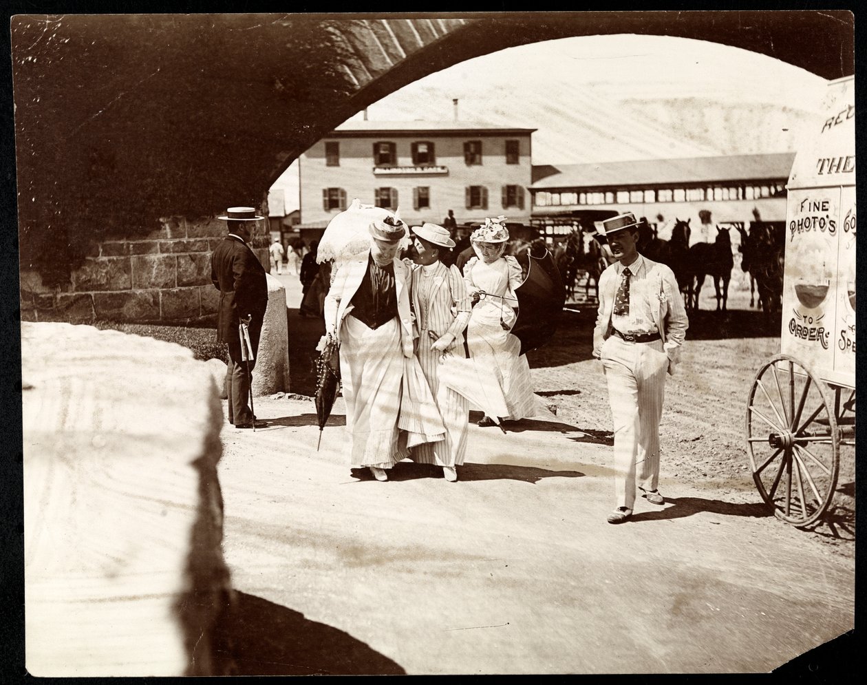 Tre kvinder og en mand går ved Narragansett Pier med omrejsende fotografs vogn, Rhode Island, 1891 (sølv gelatinetryk) af Byron Company