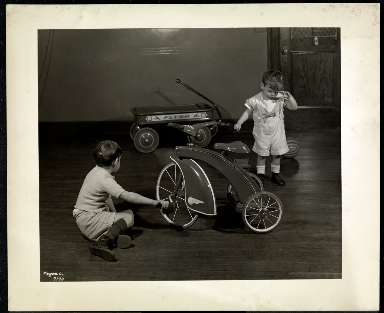 To blinde, synshandicappede drenge leger med en trehjulet cykel og en rød vogn i New York Association for the Blind, 111 East 59th Street, New York, 1937 (sølvgelatineprint) af Byron Company