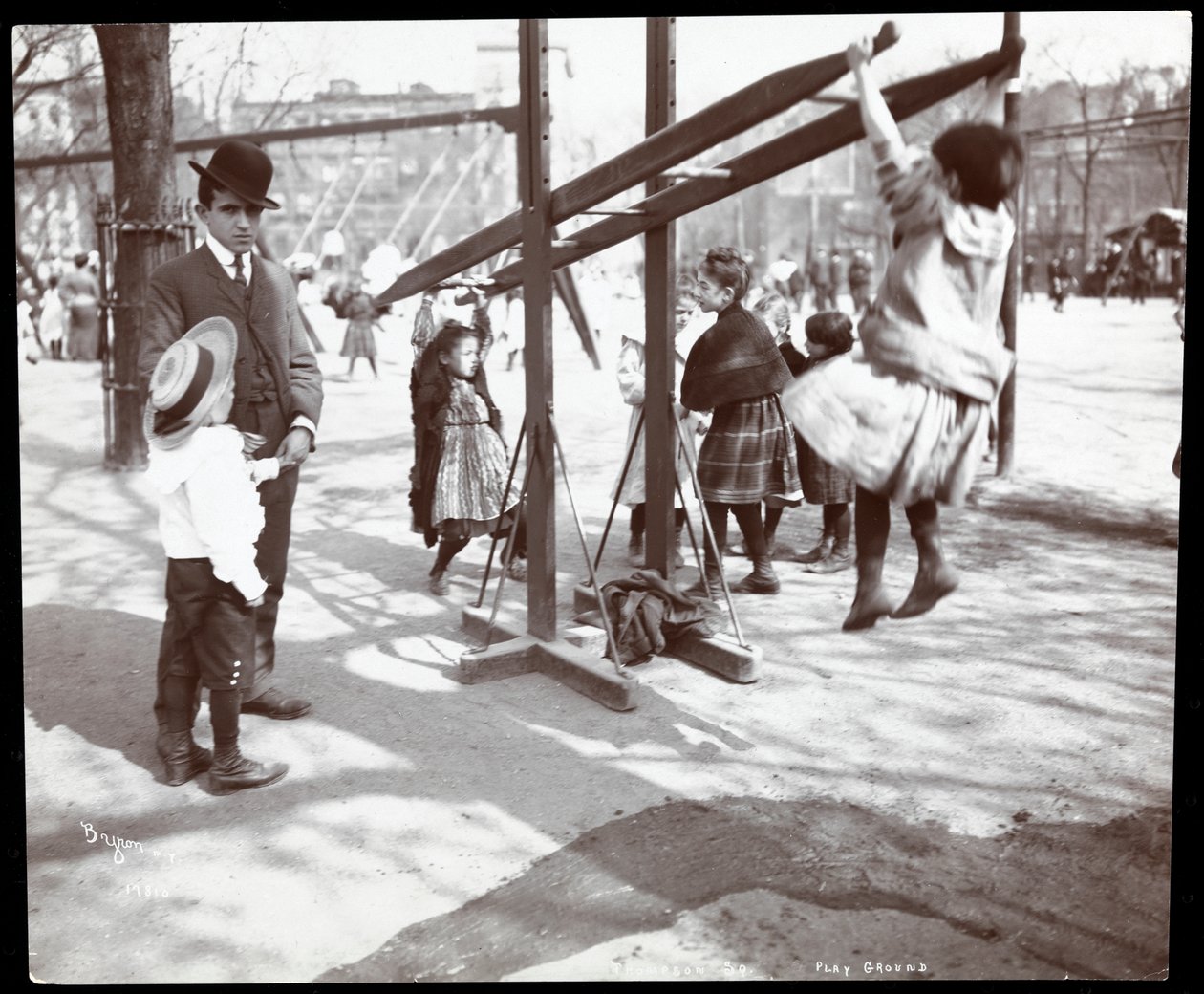 Udsigt af en mand, der fører tilsyn med børn, der leger på legeredskaber i Tompkins Square Park, på Arbor Day, New York, 1904 (sølv gelatinetryk) af Byron Company