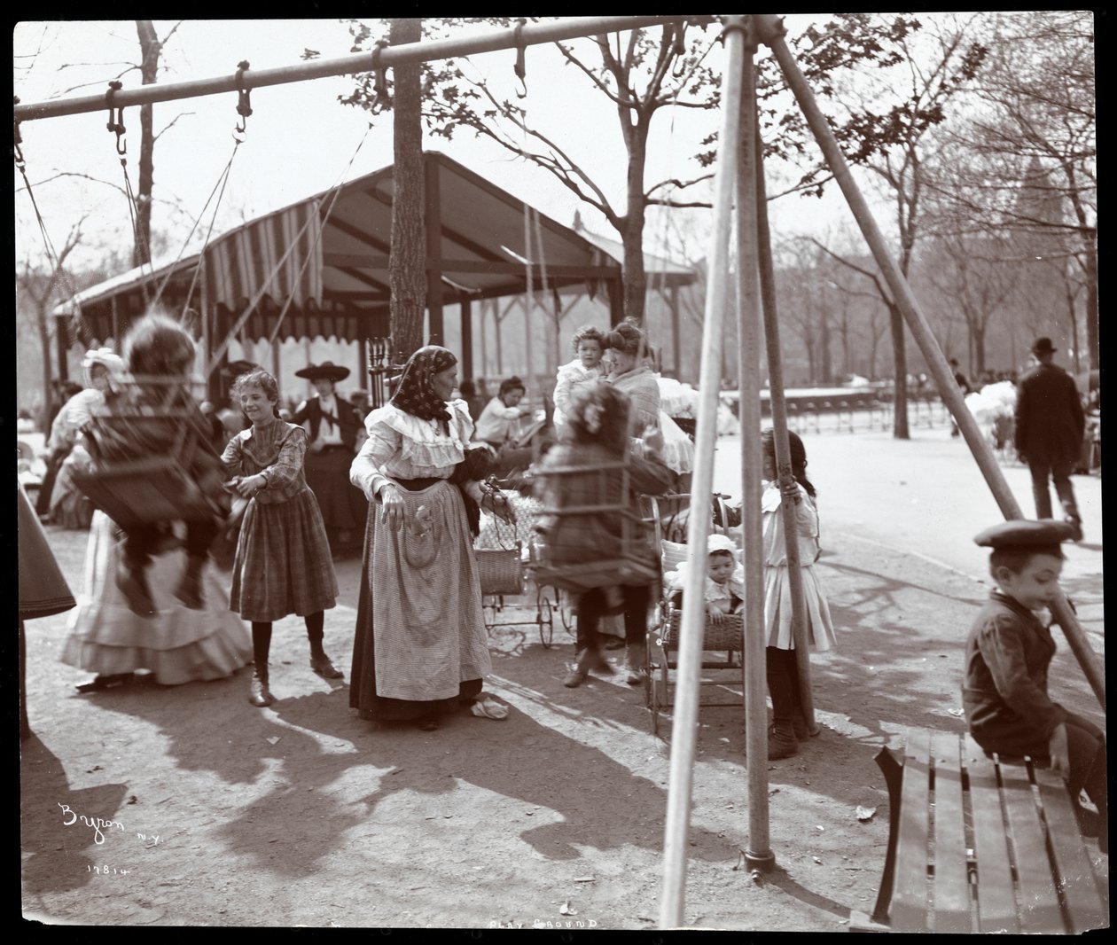 Udsigt af en kvinde, der skubber børn på gyngerne ved Tompkins Square Park, på Arbor Day, New York, 1904 (sølv gelatinetryk) af Byron Company