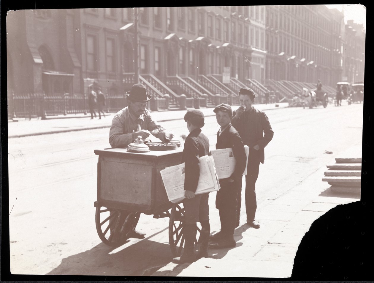 Udsigt til en ishandler på gaden, med tre avisknægte, der køber is, New York, ca. 1901 (sølvgelatineprint) af Byron Company