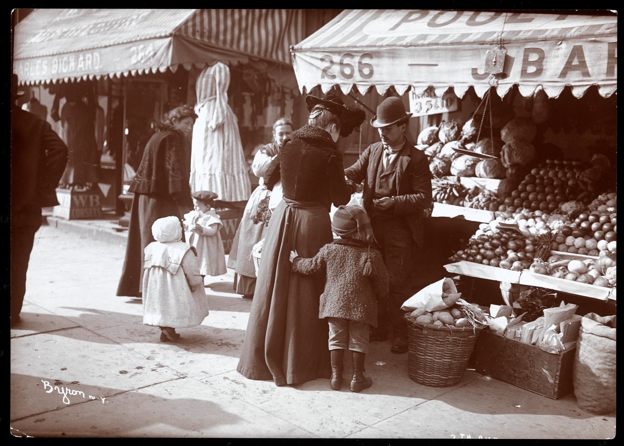 Udsigt over kvinder med børn, der shopper ved en frugt- og grøntsagsstand på 266 7th Avenue, New York, ca. 1900 (sølv gelatinetryk) af Byron Company