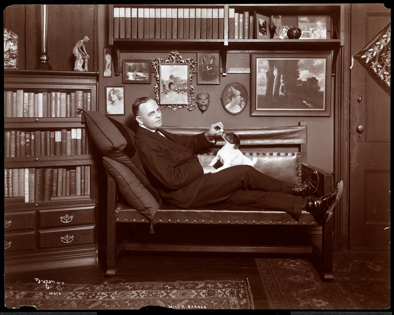 Will R. Barnes ligger på en sofa med en hund i sit biblioteksstudie, 1903 (sølvgelatineprint) af Byron Company