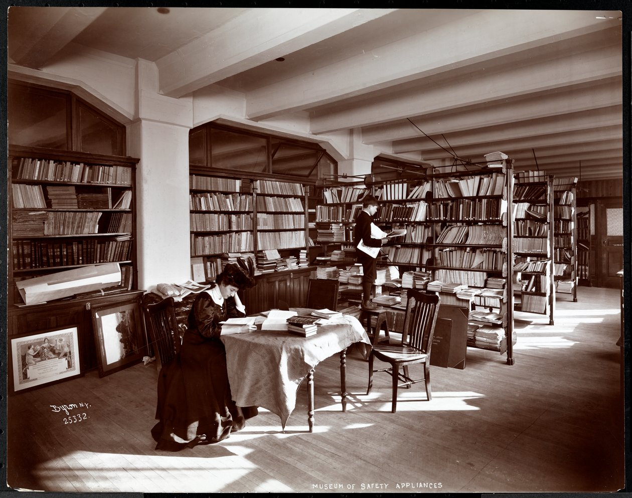 Kvinde og en ung mand i et bibliotek i Museum of Safety Appliances fra American Institute of Social Service, New York, 1907 (sølv gelatinetryk) af Byron Company