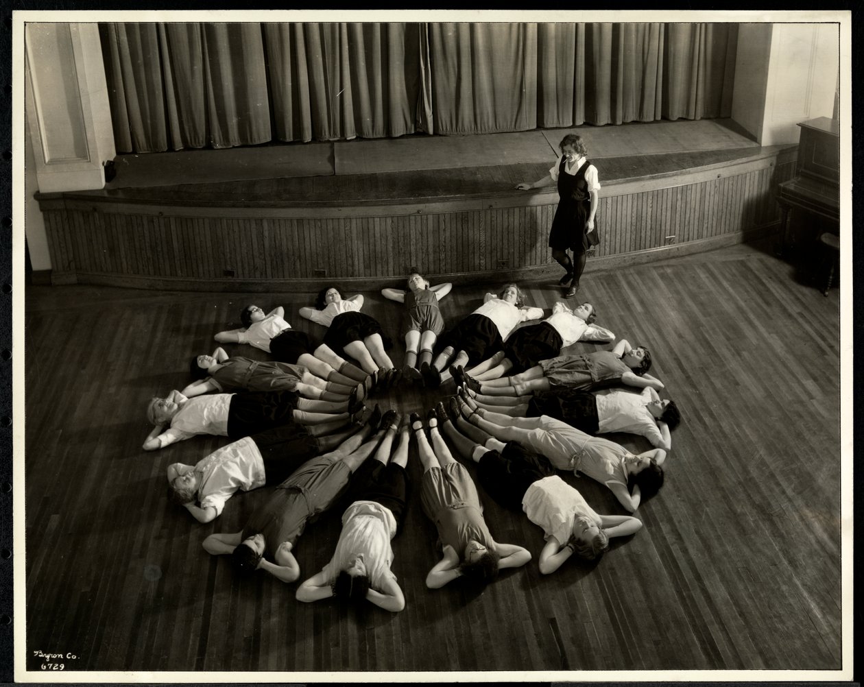 Unge blinde kvinder liggende i et stjerneskudsmønster på gulvet i gymnastiksalen i New York Association for the Blind, 111 East 59th Street, New York, 1933 (sølv gelatinetryk) af Byron Company