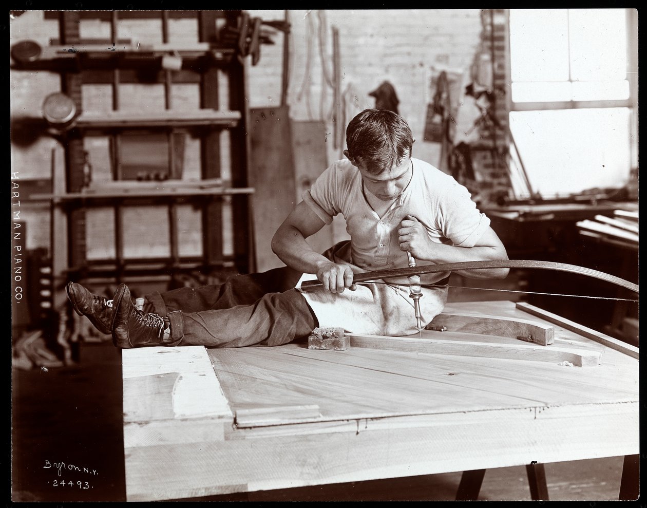 En mand, der arbejder på Hartman Piano Co. fabrikken, 1907 (sølv gelatinetryk) af Byron Company