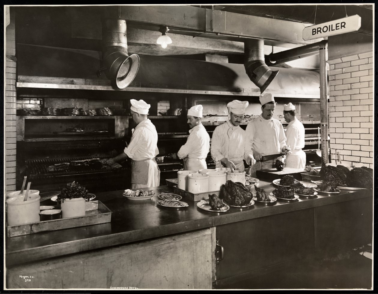 Kokker ved slagtekyllingen i køkkenet på Hotel Commodore, 1919 (sølv gelatinetryk) af Byron Company