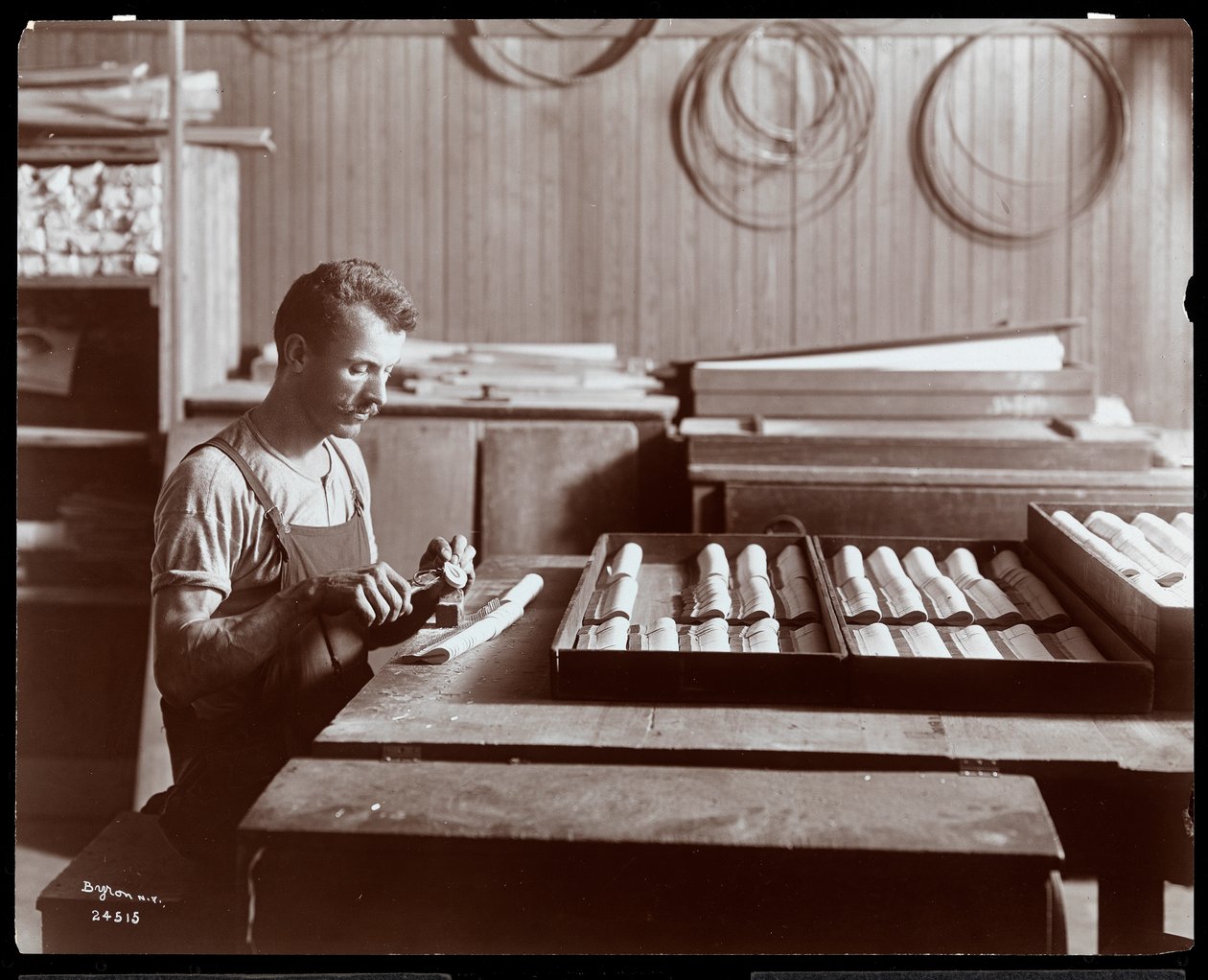 Mand arbejder i Hardman, Peck und Co. klaverfabrik, New York, 1907 (sølvgelatineprint) af Byron Company