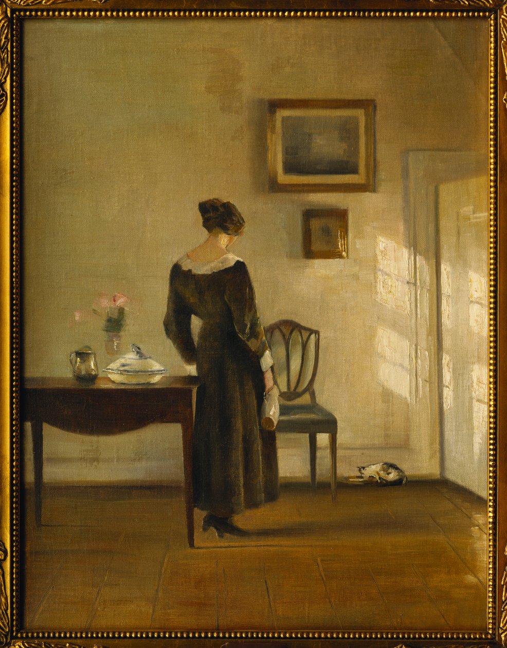 Et interiør med en kvinde, der fodrer en kat (olie på lærred) af Carl Holsoe