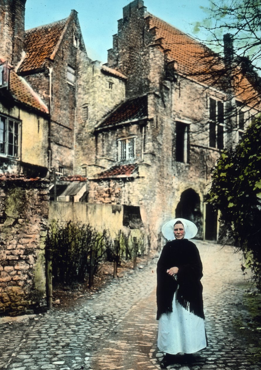 Holland, provinsen Zeeland. Kvinde foran Kuipers-portalen i byen Middelburg. Billeddato: ca. 1920. Carl Simon-arkivet af Carl Simon