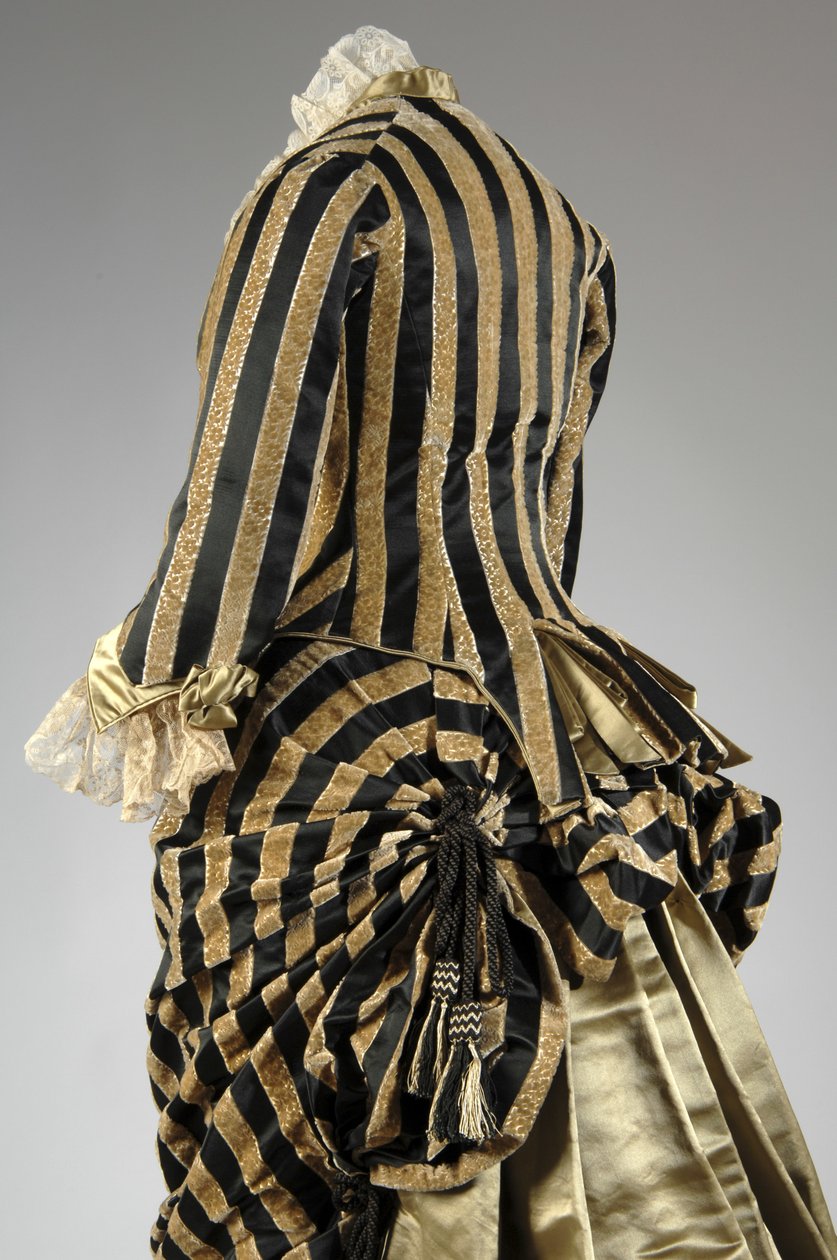 Aftenkjole, ca. 1884 (skrå bagside delvis udsigt). Silke satin og skåret fløjl, blonder, silketråd kvaster og frynser. Charles Frederick Worth, Frankrig. af Charles Frederick Worth