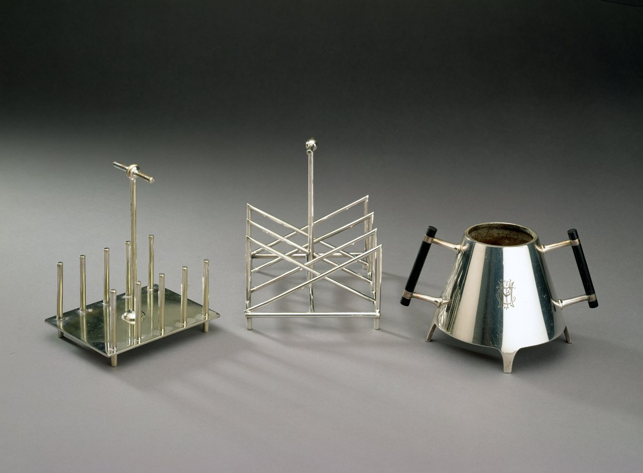 Toaststativ med opretstående understøtninger, fremstillet af Hukin & Heath, 1878 (se 46533 for detaljer); toaststativ i trekantet sektion, fremstillet af Elkington & Co., ca. 1875-88; sukkerskål med eboniseret træ h af Christopher Dresser