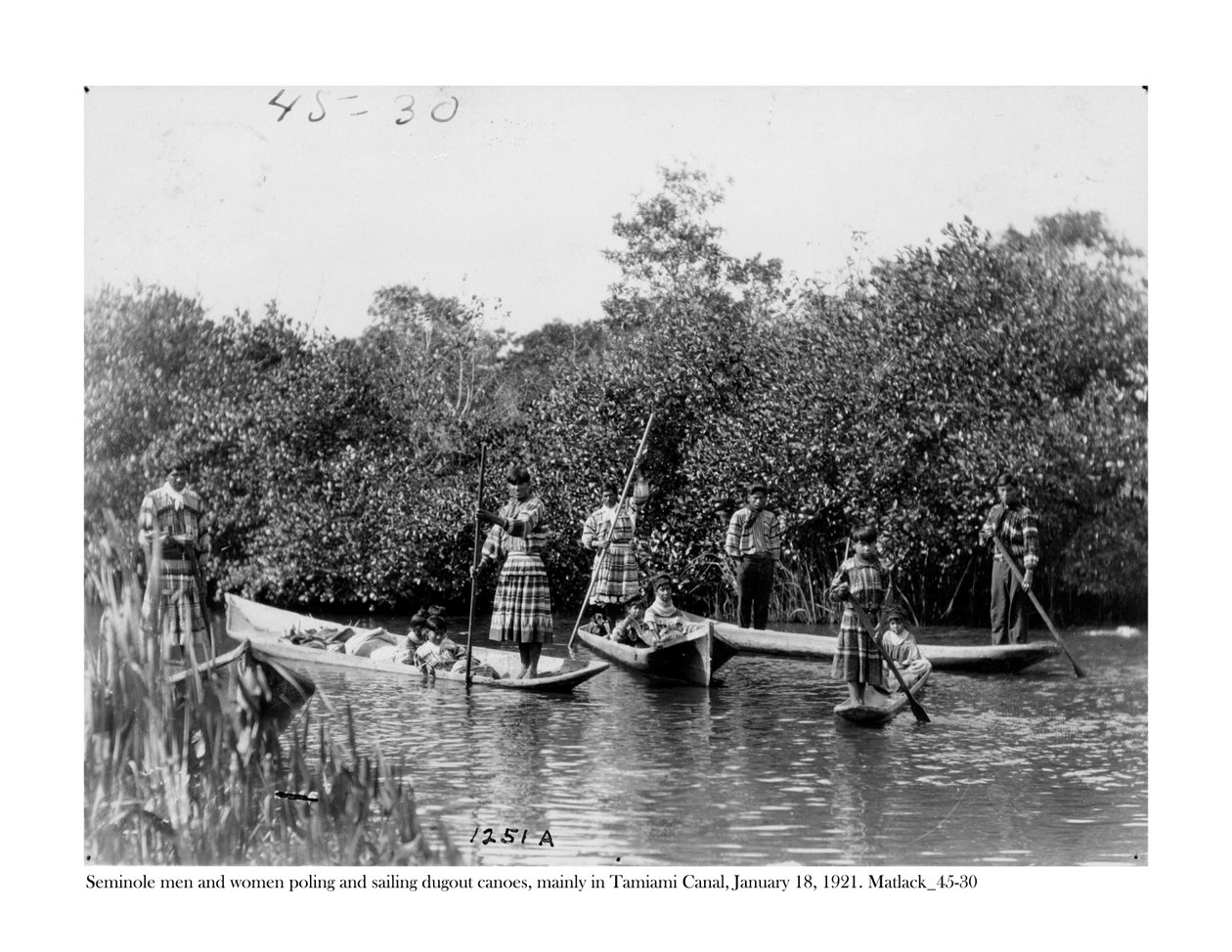 Seminole mænd og kvinder poler og sejler dugout kanoer på Tamiami Canal, 18. januar, 1921 af Claude C. Matlack