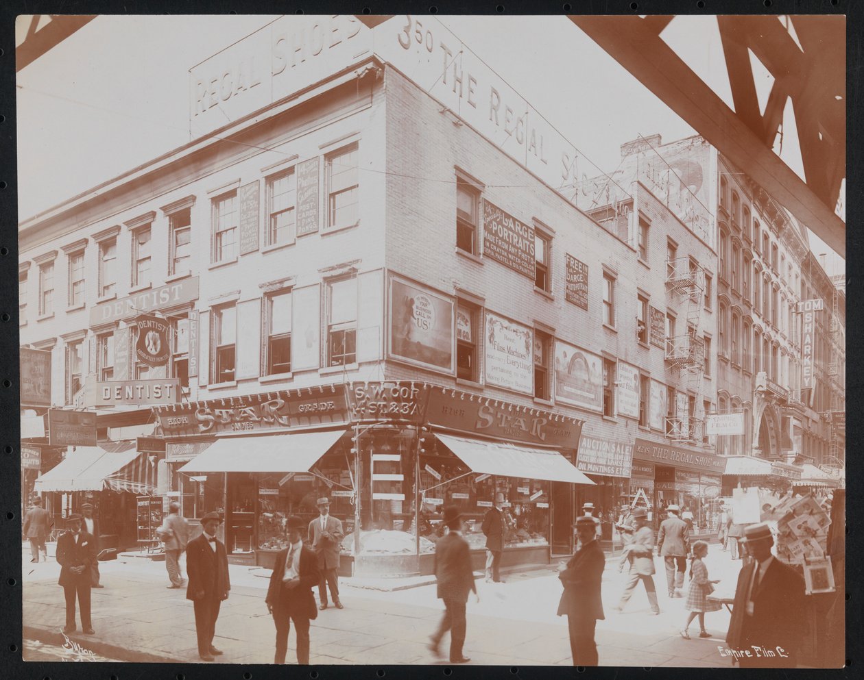 Det sydvestlige hjørne af 14th Street og 3rd Avenue, der viser Star Candies-butikken, en tandlæge, Regal Shoe-butikken og Empire Film Co. med fodgængere, reklametavler og en bjælke fra 3rd Avenue elevated railroad synlig, ca. 1905 (b/ w foto) af Company Byron