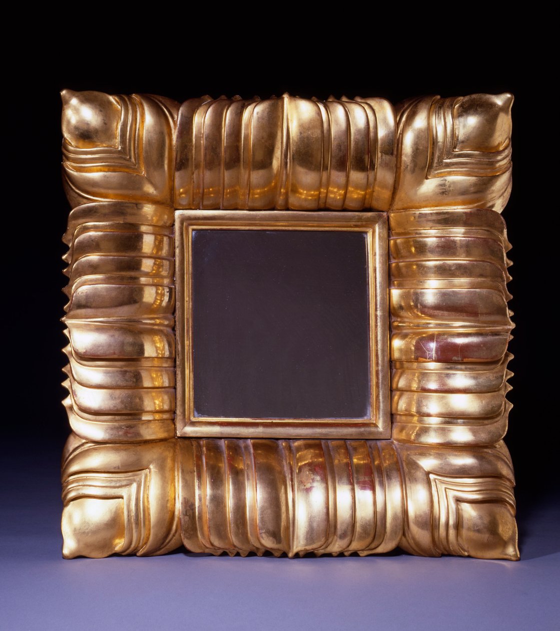 Et forgyldt træspejl, designet af Dagobert Peche (1887-1923), udskåret med overlappende stiliseret bladblad, ca. 1925 (forgyldt træ) af Dagobert Peche