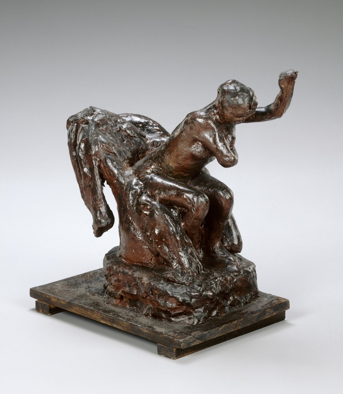 Kvinde, der sidder i en lænestol, tørrer sin venstre armhule, ca. 1890